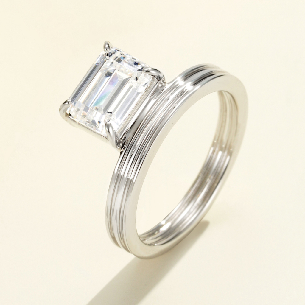 Bold and modern sterling silver ring featuring a large emerald-cut cubic zirconia center stone in a four-prong setting, paired with a wide, textured band with vertical grooves for a sophisticated and contemporary look.