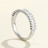 Sleek and modern half-eternity sterling silver band ring featuring a row of baguette-cut cubic zirconia stones set in a channel setting, creating a sophisticated and elegant look perfect for adding a touch of glamour to any outfit.