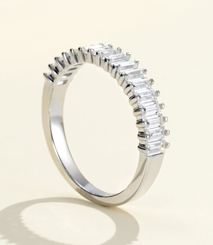 Sleek and modern half-eternity sterling silver band ring featuring a row of baguette-cut cubic zirconia stones set in a channel setting, creating a sophisticated and elegant look perfect for adding a touch of glamour to any outfit.