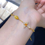 orange cross silver bracelet on wrist