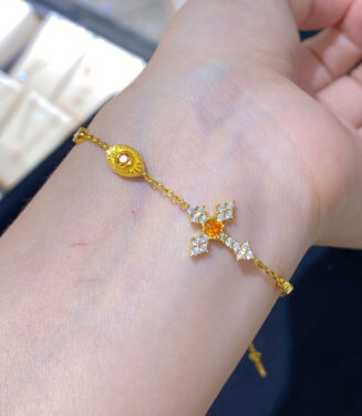 orange cross silver bracelet on wrist