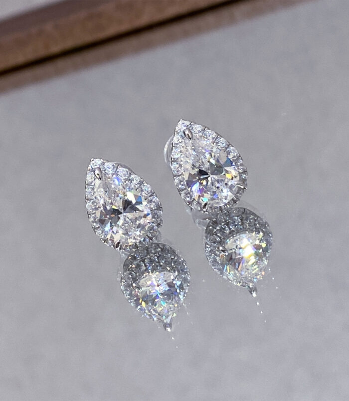 Sterling Silver Pear-Shaped Stud Earrings reflected beautifully on a mirror
