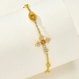 Side view of 18k gold plated 925 silver bracelet, plus a orange cross and eye shape cluster.