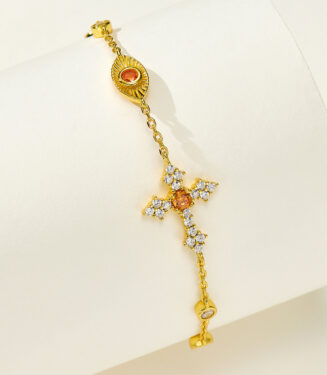 Side view of 18k gold plated 925 silver bracelet, plus a orange cross and eye shape cluster.
