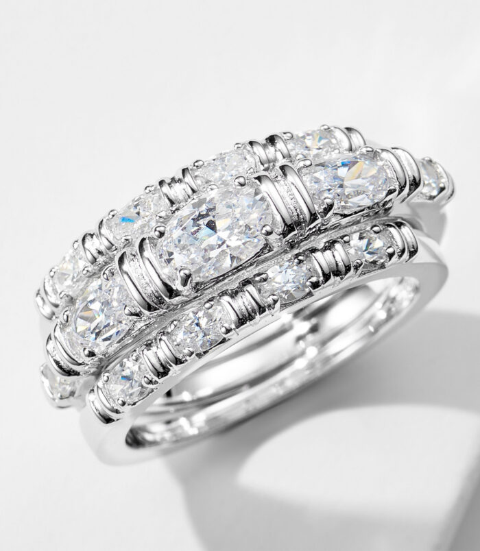 three 925 sterling silver stackable rings worn together, featuring a combination of a solitaire-style ring with a oval-cut cubic zirconia stone and a pavé-set band, and a sleek eternity band with oval cubic zirconia stones, creating a modern and elegant look.