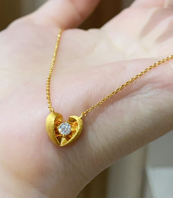 gold plated 925 Sterling Silver Brushed Heart Necklace handheld details hand held close-up of gold plated 925 Sterling Silver Brushed Heart Necklace