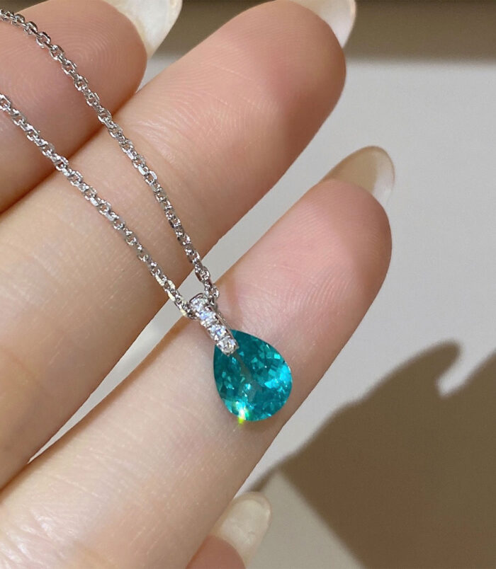 hand held close-up of Rhodium plated Minimalist Sterling Silver Pear-Shaped Paraiba Necklace