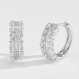 Sterling silver huggie hoop earrings with alternating round and baguette-cut cubic zirconia stones, polished finish.