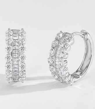 Sterling silver huggie hoop earrings with alternating round and baguette-cut cubic zirconia stones, polished finish.