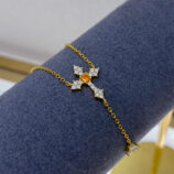 Gold-Plated Sterling Silver Cross Y-Necklace displayed on a dark blue jewelry stand