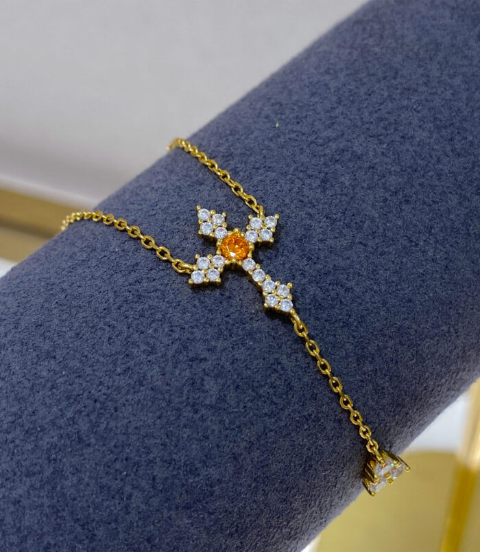 Gold-Plated Sterling Silver Cross Y-Necklace displayed on a dark blue jewelry stand