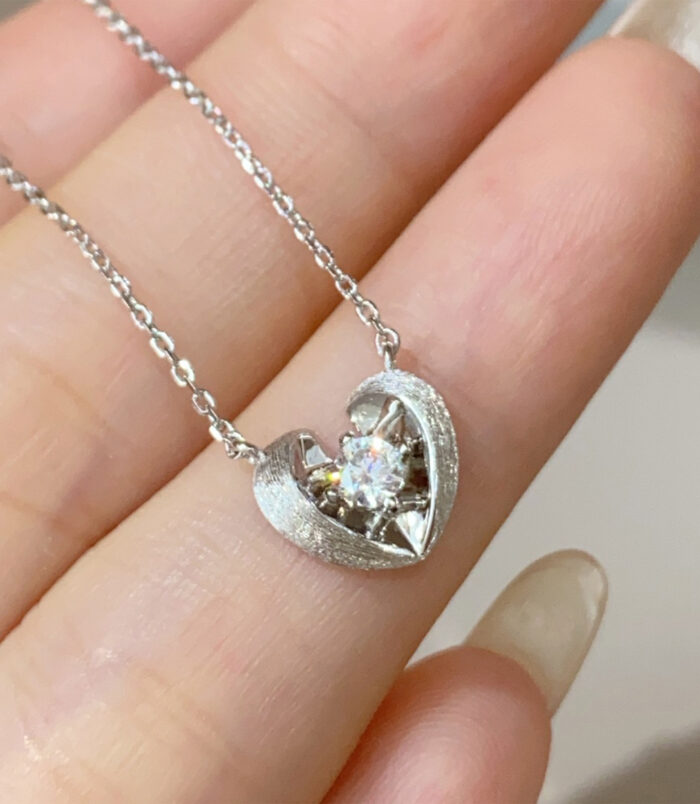 Rhodium plated 925 Sterling Silver Brushed Heart Necklace handheld details hand held close-up of Rhodium plated 925 Sterling Silver Brushed Heart Necklace