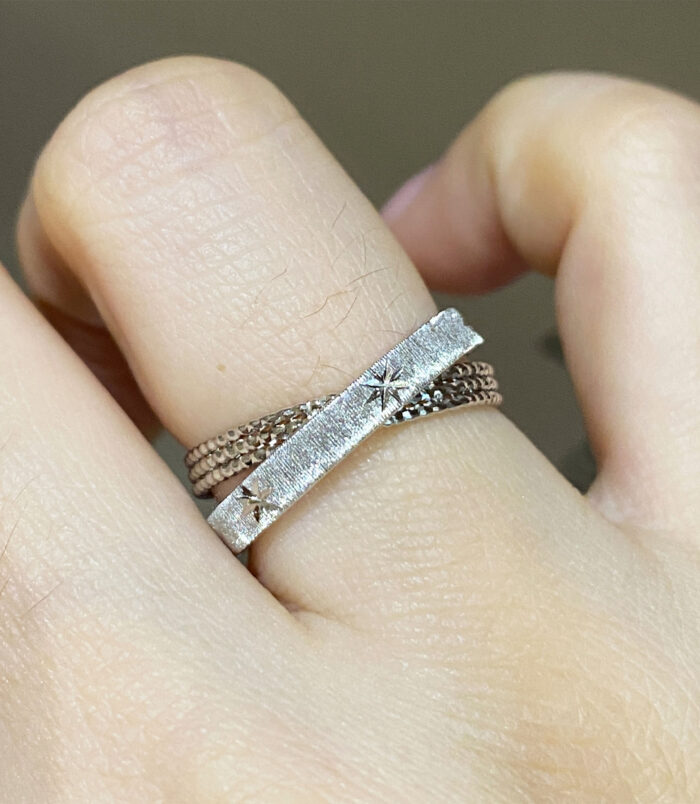 Rhodium plated Sterling Silver Star Engraved Textured Bands wearing effect Rhodium plated Sterling Silver Star Engraved Textured Bands worn on a model's finger