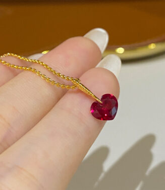 hand held close-up of Charming Sterling Silver Heart-Shaped Red Zirconia Stone Necklace