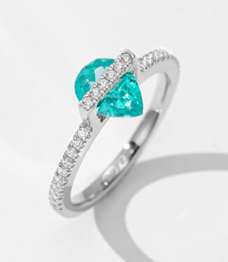 A striking sterling silver ring featuring a pear-shaped paraiba tourmaline as the centerpiece, complemented by sparkling diamond accents along the band.