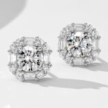 Luxurious sterling silver stud earrings, featuring a large round brilliant-cut white cubic zirconia stone as the centerpiece, surrounded by a halo of alternating baguette-cut and round brilliant-cut white cubic zirconia stones, creating a regal and sophisticated look perfect for adding a touch of glamour to any outfit.