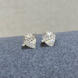 Sterling Silver Pear cut Cubic Zirconia Stud Earrings on a soft blue cloth