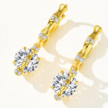 Sterling silver huggie hoop earrings with gold-plated finish, featuring a large round cubic zirconia center stone and smaller stones along the hoop.