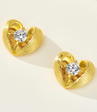 Sterling silver heart-shaped stud earrings with a brushed gold-plated finish, featuring a round clear cubic zirconia center stone.