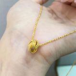 Modern Gold-Plated Sterling Silver Knot Pendant Necklace displayed in hand