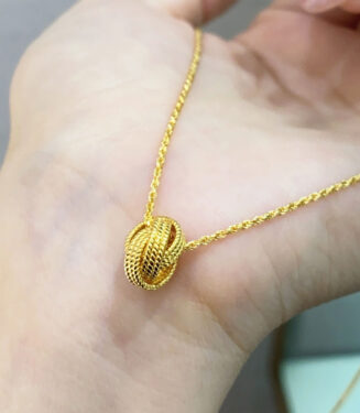 Modern Gold-Plated Sterling Silver Knot Pendant Necklace in hand Modern Gold-Plated Sterling Silver Knot Pendant Necklace displayed in hand