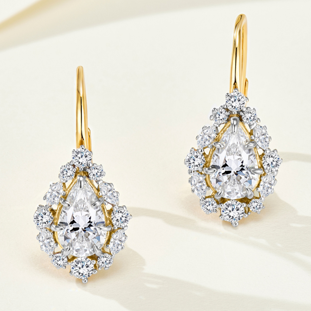 Sterling silver drop earrings with gold-plated finish, featuring a pear-cut cubic zirconia center stone surrounded by a halo of smaller stones.