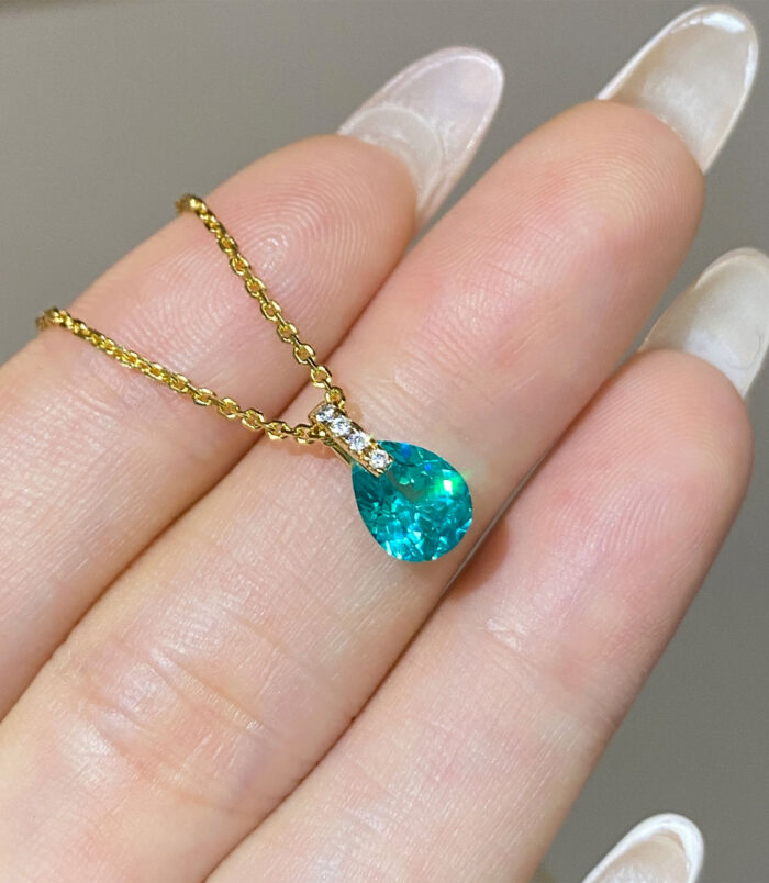 hand held close-up of gold plated Minimalist Sterling Silver Pear-Shaped Paraiba Necklace