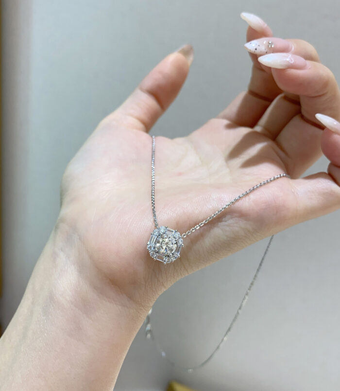 Sterling silver sugar cube zircon necklace in hand hand held close-up of Sterling silver sugar cube zircon necklace