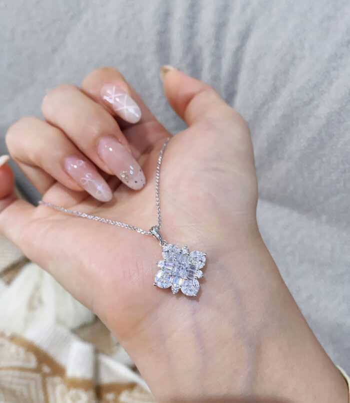 hand held close-up of Dazzling Sterling Silver Snowflake Pendant Necklace