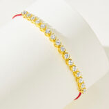 side view of gold plated 925 silver bracelet with cubic zirconia stones and a red string