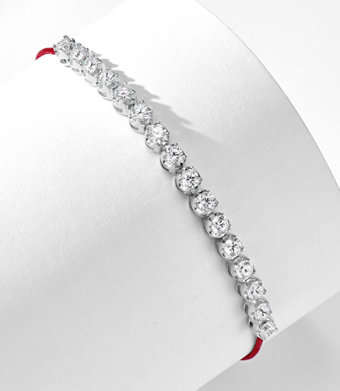 side view of Rhodium plated 925 silver bracelet with cubic zirconia stones and a red string