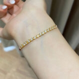 925 silver gold plated zirconia and red string bracelet on a wrist