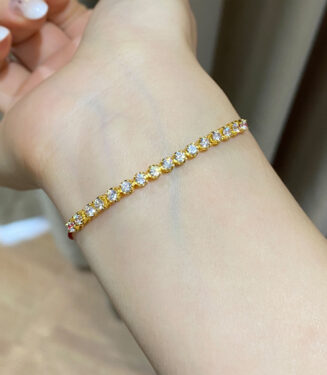 925 silver gold plated zirconia and red string bracelet on a wrist