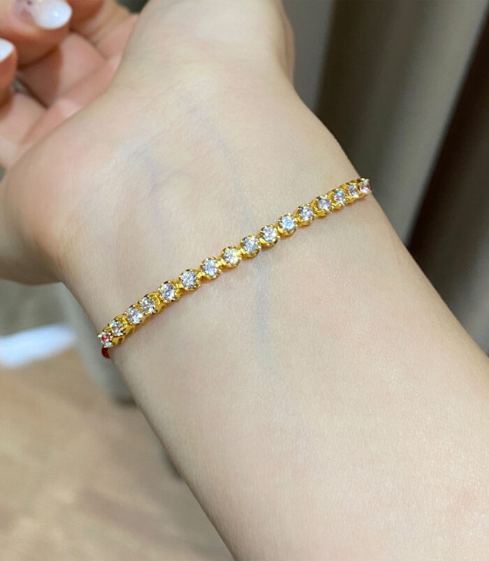 925 silver gold plated zirconia and red string bracelet on a wrist