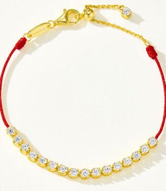 Full view of gold plated 925 silver bracelet with cubic zirconia stones and a red string